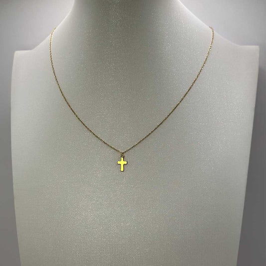 Ce joli bijou "Paula" en acier inoxydable est un collier de couleur or avec un pendentif en croix doré. Il est posé sur un buste pailleté blanc qui est lui même sur un fond blanc.